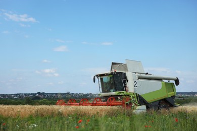 Photo of Modern combine harvester working in wheat field
