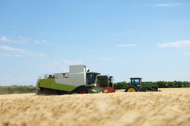 Photo of Combine harvester and tractor working in wheat field