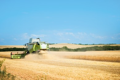 Photo of Modern combine harvester working in wheat field