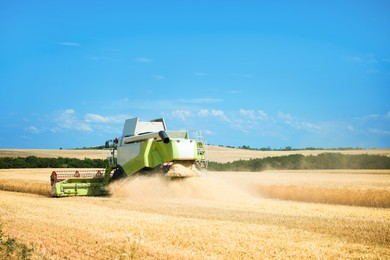 Photo of Modern combine harvester working in wheat field