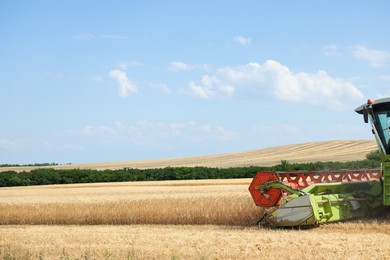 Photo of Modern combine harvester working in wheat field