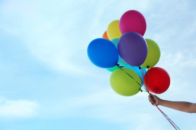 Photo of Woman with bunch of colorful balloons under beautiful sky, closeup. Space for text