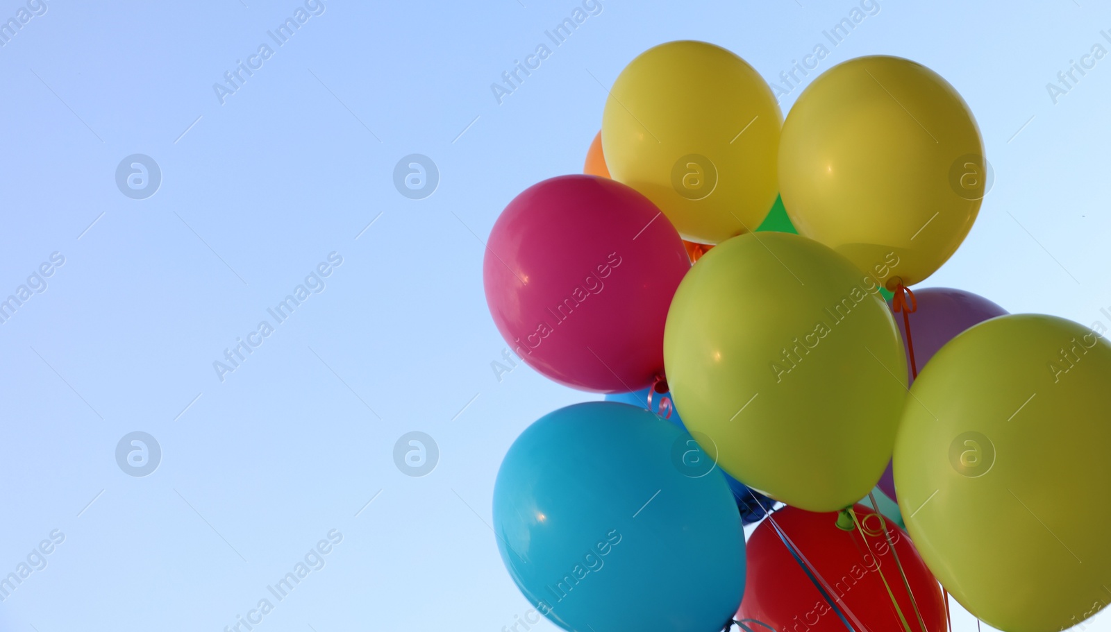 Photo of Bunch of colorful balloons under beautiful sky, low angle view. Space for text