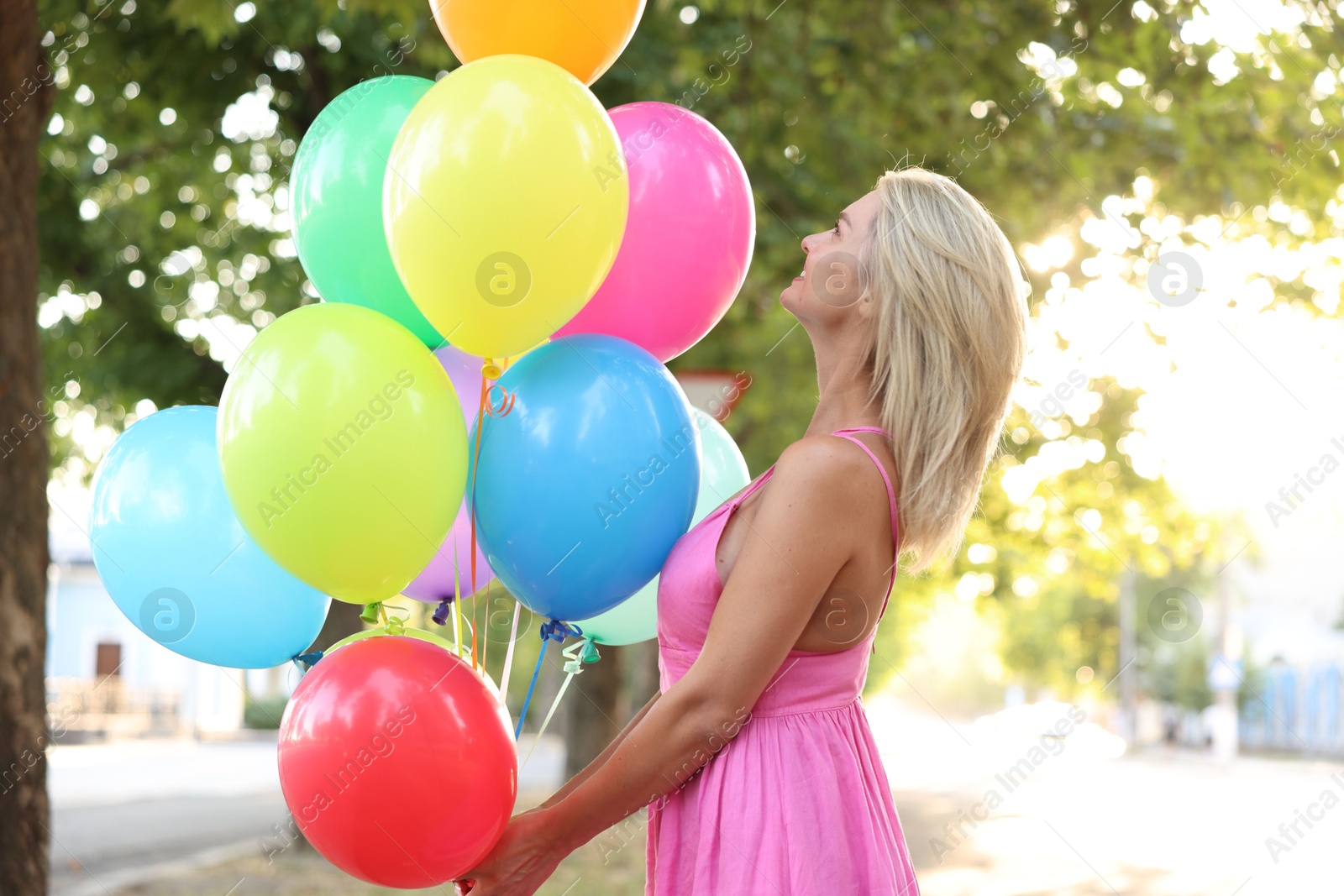 Photo of Woman with bunch of colorful balloons outdoors