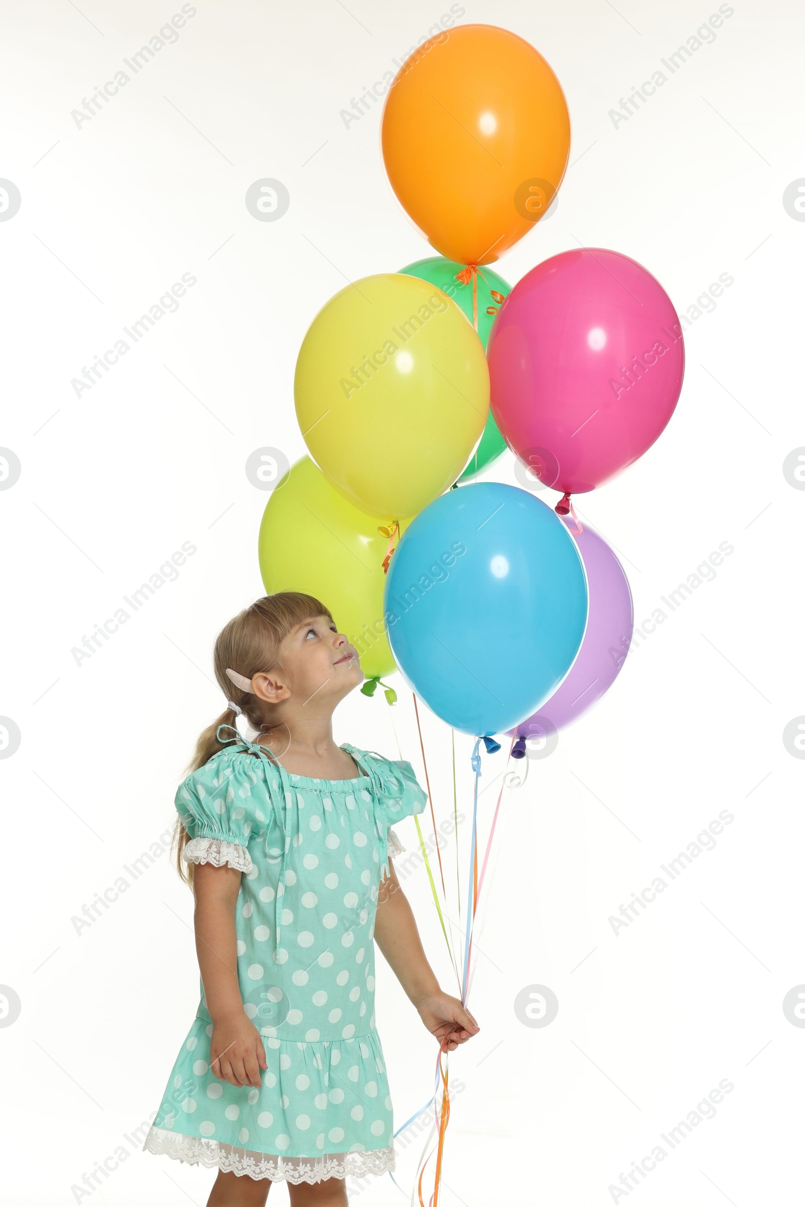 Photo of Cute little girl in dress with bunch of colorful balloons on white background