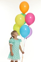 Photo of Cute little girl in dress with bunch of colorful balloons on white background