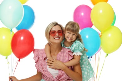 Photo of Happy mother in sunglasses and her little daughter with bunches of colorful balloons on white background