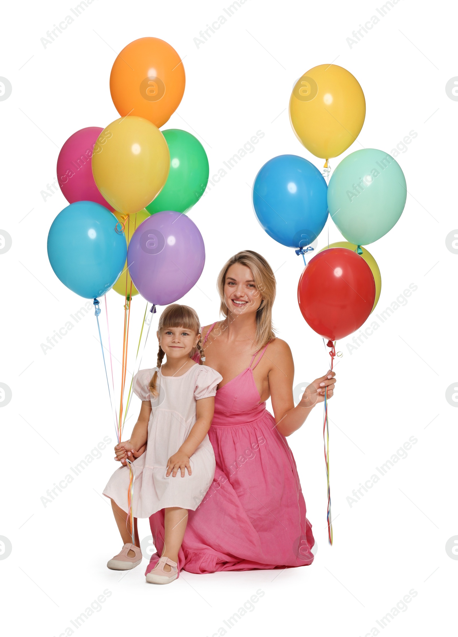 Happy mother in dress and her little daughter with bunches of colorful balloons on white background Photo of Happy mother in dress and her little daughter with bunches of colorful balloons on white background