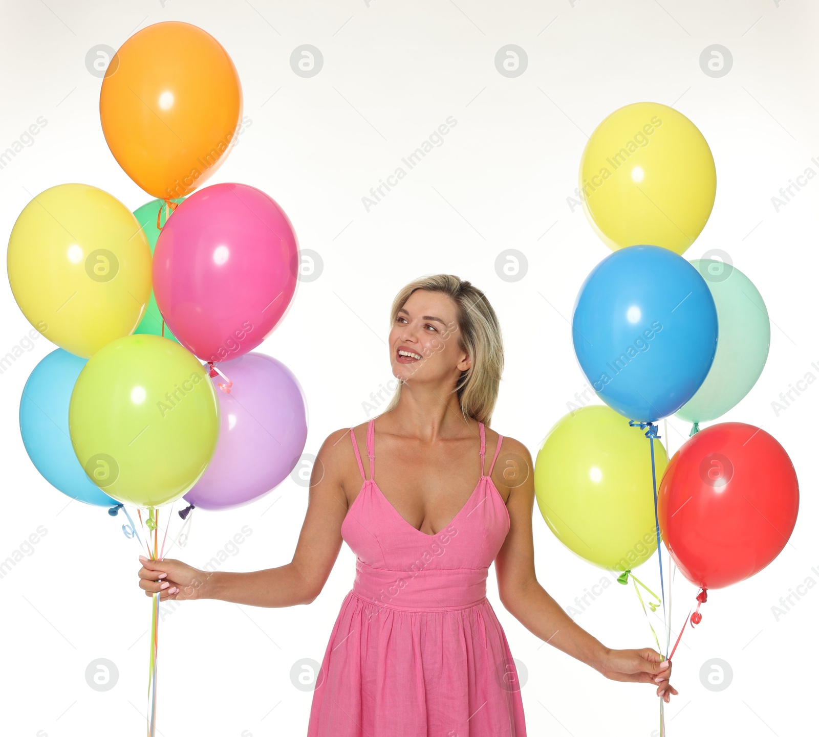 Smiling woman in dress with bunches of colorful balloons on white background Photo of Smiling woman in dress with bunches of colorful balloons on white background