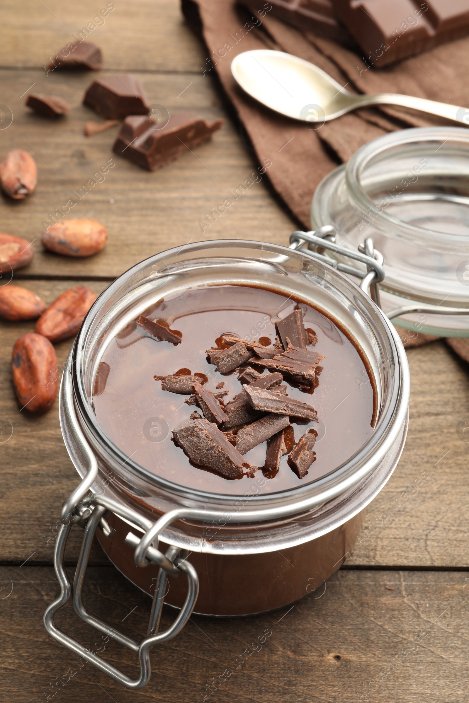 Delicious chocolate panna cotta in glass jar, nuts and spoon on wooden table, closeup Photo of Delicious chocolate panna cotta in glass jar, nuts and spoon on wooden table, closeup