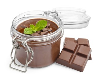 Photo of Delicious panna cotta in glass jar, pieces of chocolate and mint isolated on white