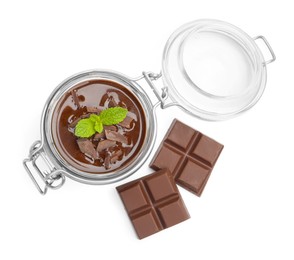 Photo of Delicious panna cotta in glass jar, pieces of chocolate and mint isolated on white, top view