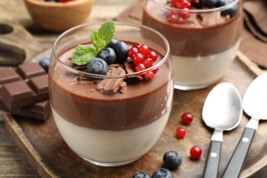 Photo of Delicious panna cotta with chocolate, berries and mint on table, closeup