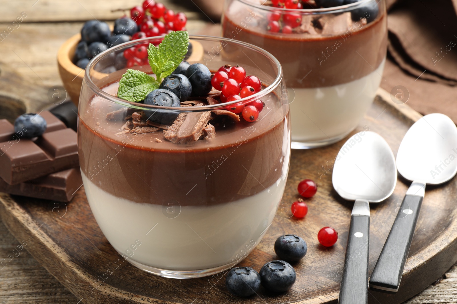 Delicious panna cotta with chocolate, berries and mint on wooden table, closeup Photo of Delicious panna cotta with chocolate, berries and mint on wooden table, closeup