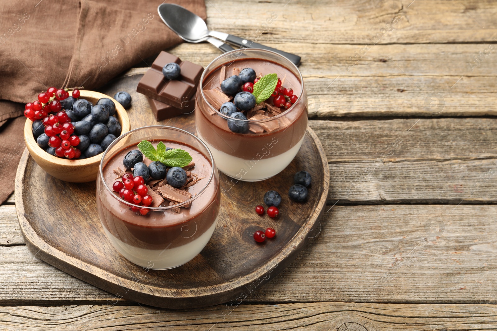 Delicious panna cotta with chocolate, berries and mint on wooden table, closeup. Space for text Photo of Delicious panna cotta with chocolate, berries and mint on wooden table, closeup. Space for text