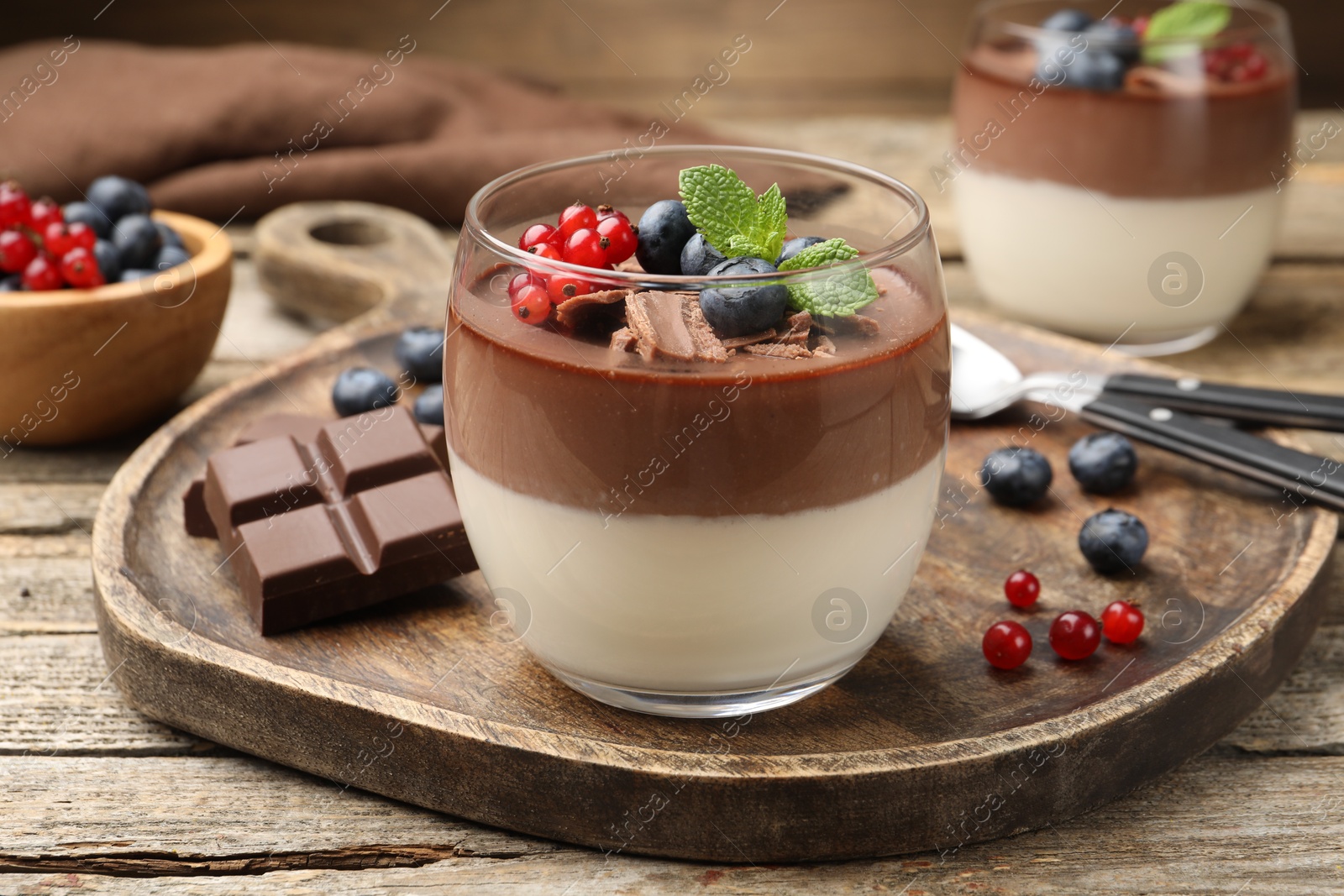 Delicious panna cotta with chocolate, berries and mint on wooden table, closeup Photo of Delicious panna cotta with chocolate, berries and mint on wooden table, closeup