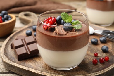 Photo of Delicious panna cotta with chocolate, berries and mint on table, closeup