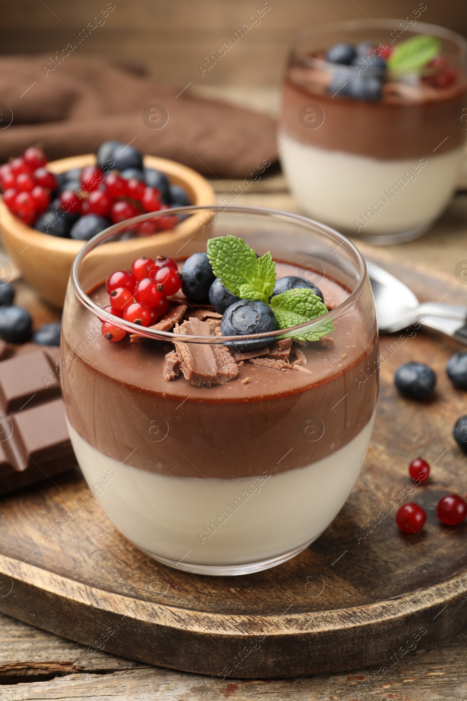 Delicious panna cotta with chocolate, berries and mint on wooden table, closeup Photo of Delicious panna cotta with chocolate, berries and mint on wooden table, closeup