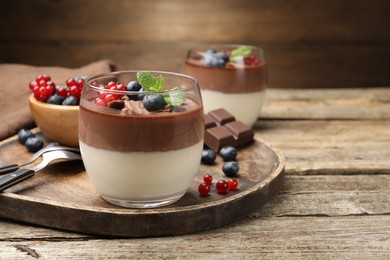 Photo of Delicious panna cotta with chocolate, berries and mint on wooden table, closeup. Space for text