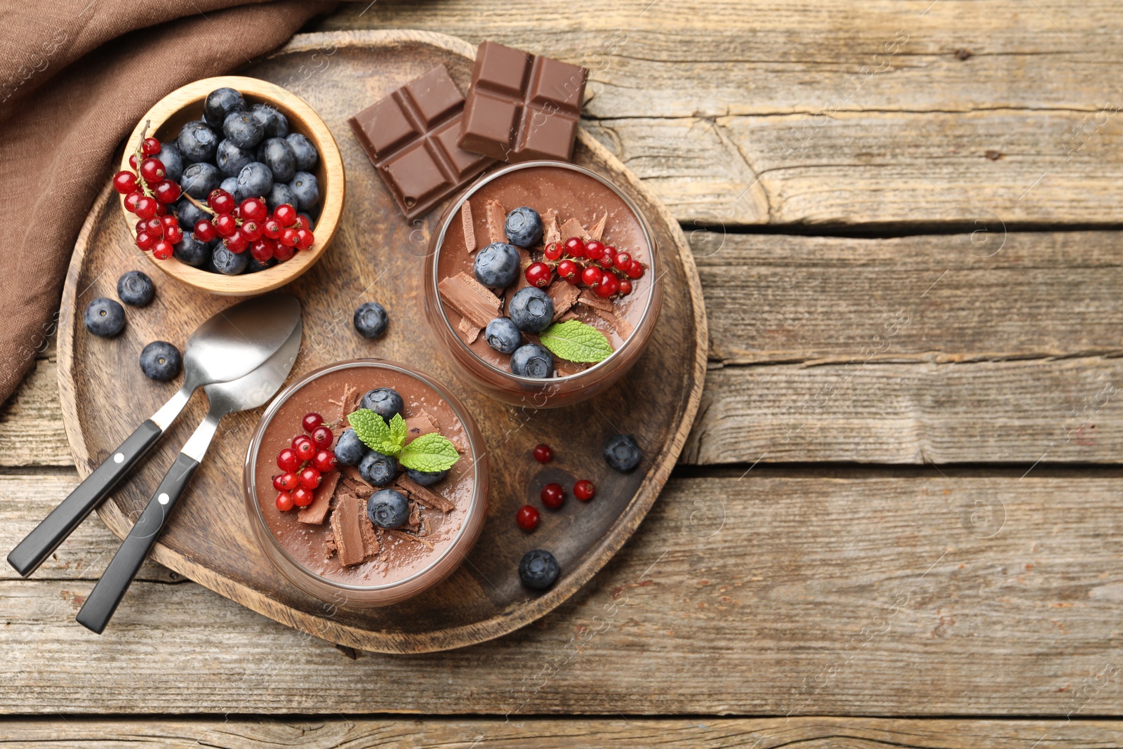 Delicious panna cotta with chocolate, berries and mint on wooden table, top view. Space for text Photo of Delicious panna cotta with chocolate, berries and mint on wooden table, top view. Space for text