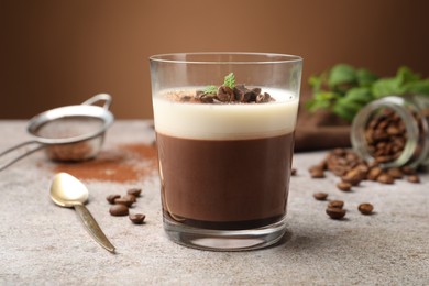 Photo of Delicious coffee panna cotta, beans and mint on grey table, closeup