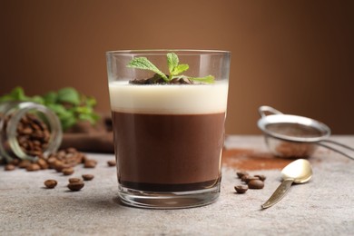 Photo of Delicious coffee panna cotta, beans and mint on grey table, closeup