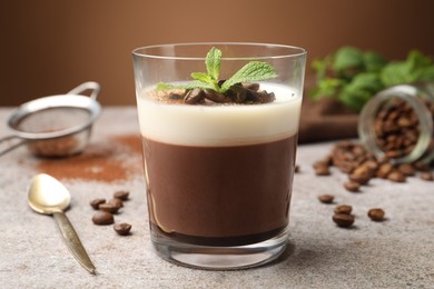 Photo of Delicious coffee panna cotta, beans and mint on grey table, closeup