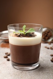 Photo of Delicious coffee panna cotta, beans and mint on grey table, closeup