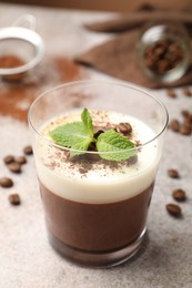 Photo of Delicious coffee panna cotta, beans and mint on grey table, closeup