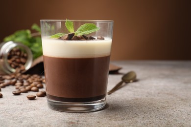 Photo of Delicious coffee panna cotta, beans and mint on grey table, closeup. Space for text
