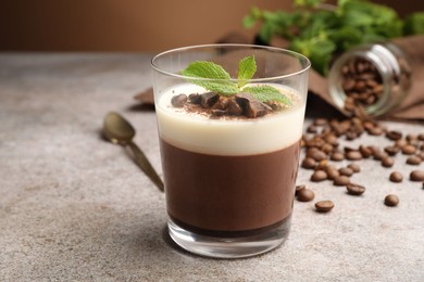 Photo of Delicious coffee panna cotta, beans and mint on grey table, closeup