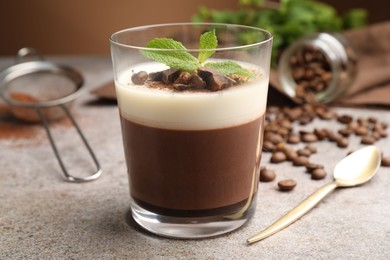 Photo of Delicious coffee panna cotta, beans and mint on grey table, closeup