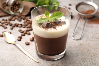 Photo of Delicious coffee panna cotta, beans and mint on grey table, closeup