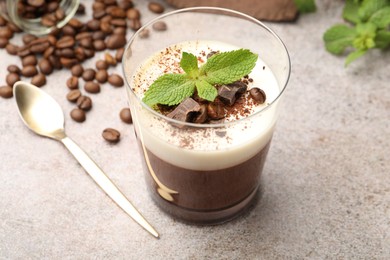 Photo of Delicious coffee panna cotta, beans and mint on grey table, closeup