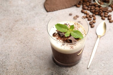 Photo of Delicious coffee panna cotta, beans and mint on grey table, closeup. Space for text