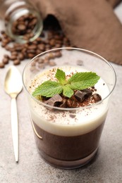 Photo of Delicious coffee panna cotta, beans and mint on grey table, closeup
