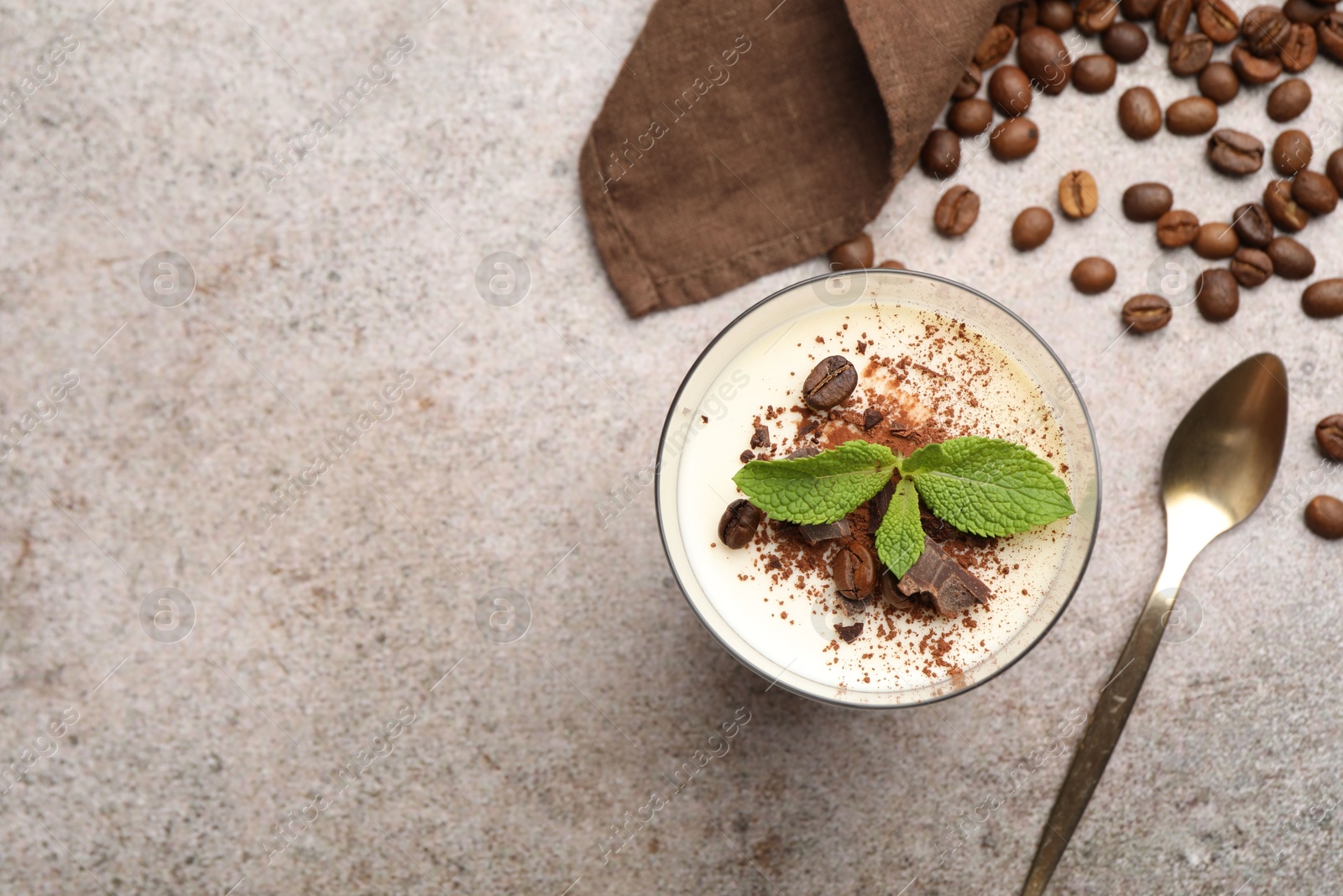 Delicious coffee panna cotta, spoon, beans and mint on grey table, flat lay. Space for text Photo of Delicious coffee panna cotta, spoon, beans and mint on grey table, flat lay. Space for text