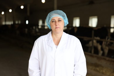 Photo of Portrait of veterinarian inside cowshed in dairy farm