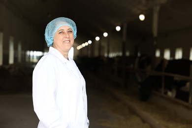 Photo of Portrait of veterinarian inside cowshed in dairy farm, space for text