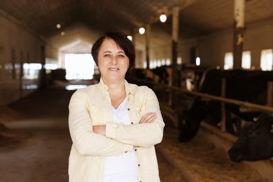 Photo of Portrait of farmer near cute cows inside cowshed in dairy farm