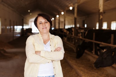 Photo of Portrait of farmer inside cowshed in dairy farm, space for text