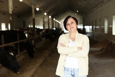 Photo of Portrait of farmer inside cowshed in dairy farm, space for text