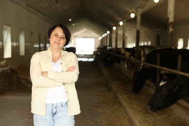 Photo of Portrait of farmer inside cowshed in dairy farm, space for text