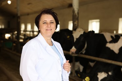 Photo of Portrait of farmer near cute cows inside cowshed in dairy farm