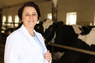 Photo of Portrait of farmer near cute cows inside cowshed in dairy farm