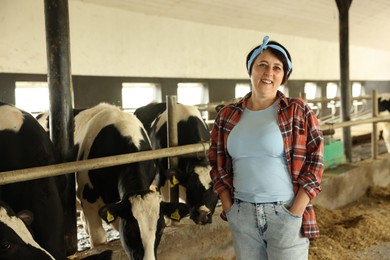 Photo of Portrait of farmer near cute cows inside cowshed in dairy farm