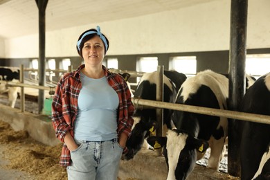 Photo of Portrait of farmer near cute cows inside cowshed in dairy farm