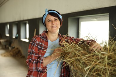 Photo of Portrait of farmer with hay in dairy farm