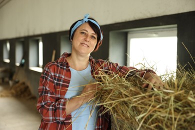 Photo of Portrait of farmer with hay in dairy farm