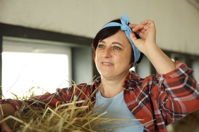 Photo of Portrait of farmer with hay in dairy farm